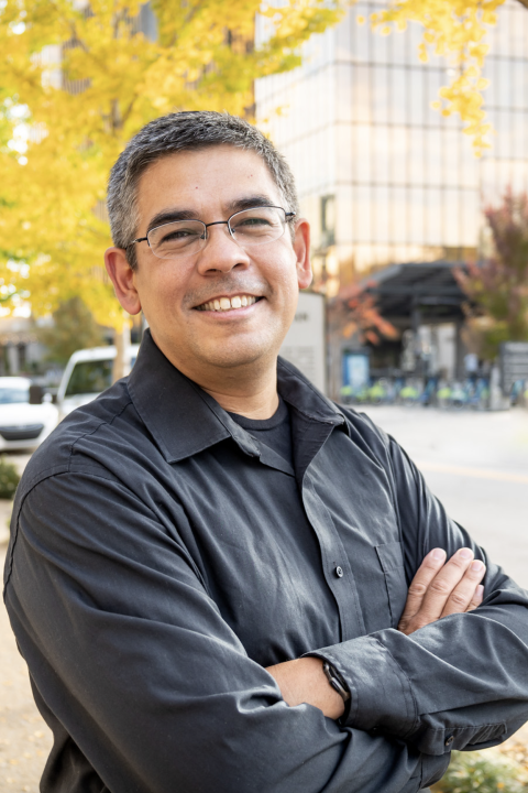 Man in front of trees smiling