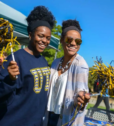 students waving blue and gold pom-poms