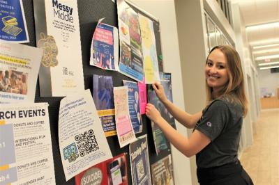 Mocs Grow 2 Student pinning things on a bulletin bord