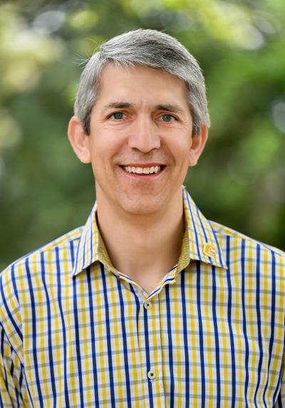 Off-Campus Housing Coordinator Headshot of Dean Topodas, a clean-shaven, middle-aged, white male with salt-and-pepper hair and Greek complexion.