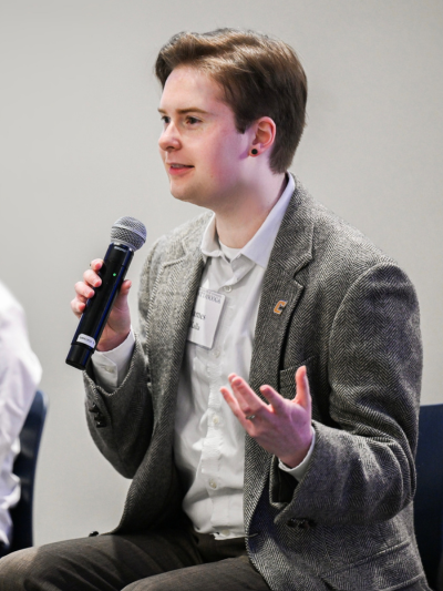 James on stage at an event holding a microphone.