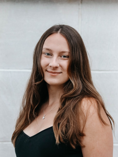 Kathryn standing in front of a wall for a headshot photo