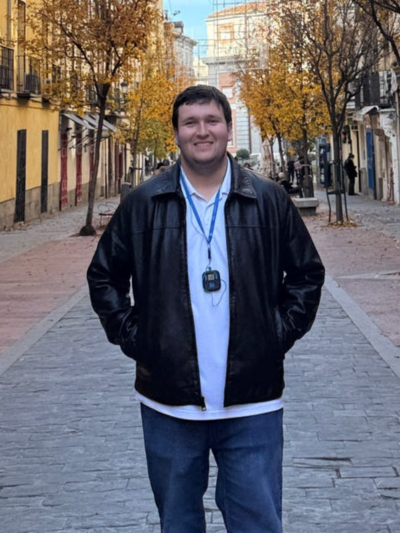 Matthew standing and posing on a sidewalk