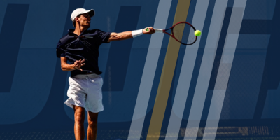 An action photo of RCOB student Kristof Kinces swinging a tennis racquet in a match.