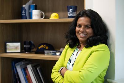 Dr. Dilhani Marasinghe stands in front of a bookcase in an office in Fletcher Hall.
