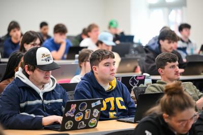 A group of students sit in a classroom during a class at RCOB