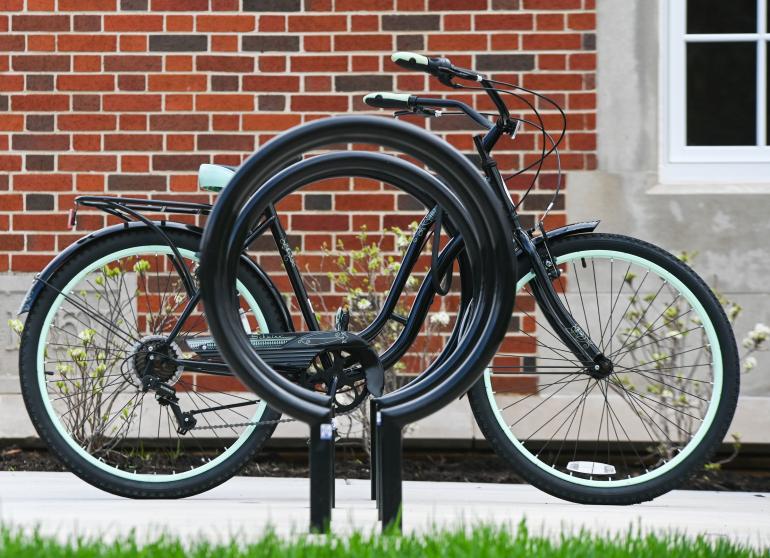 Bicycle rack with one bike parked and chained.