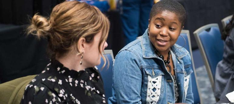 student talks with community member at a college of business event