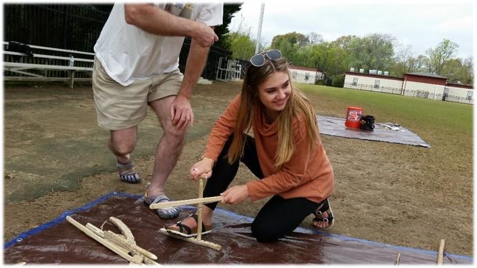 Students attempt to start a fire with sticks