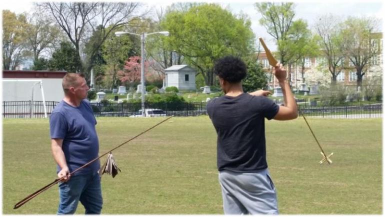 Two students hold stakes