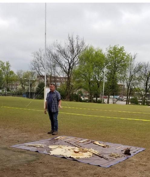 Man stands beside assortment of tools on the ground