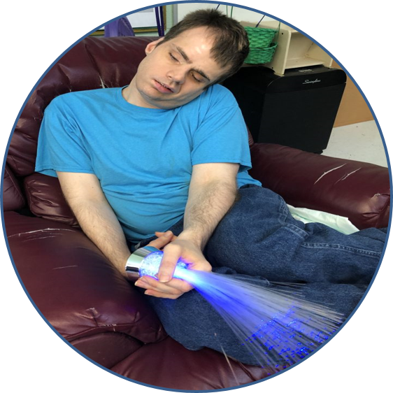 Man sleeps on couch holding fiber optic light