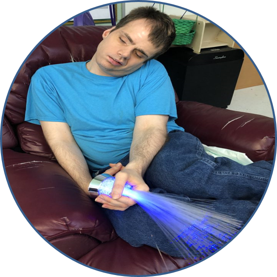 Man sleeps on couch holding fiber optic light