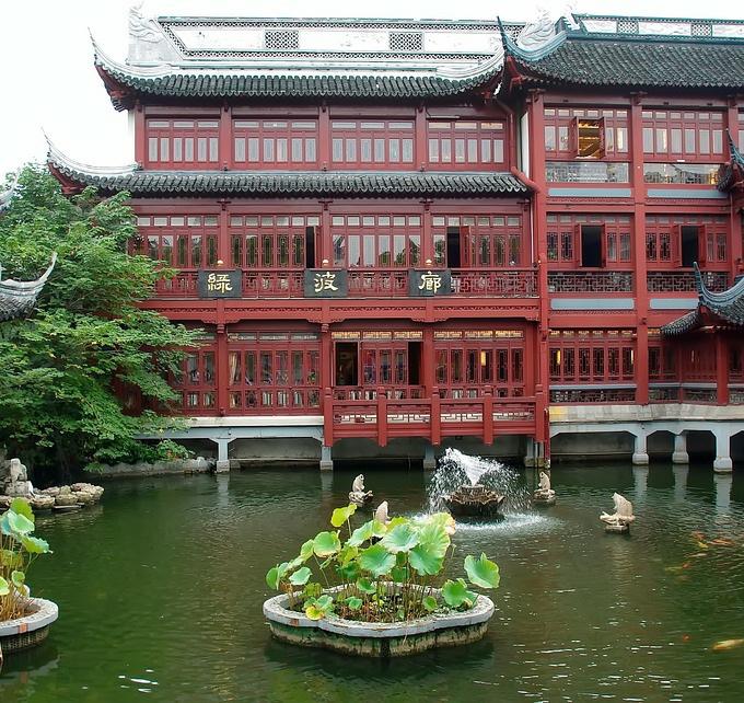Chinese building with gardens and pond in front