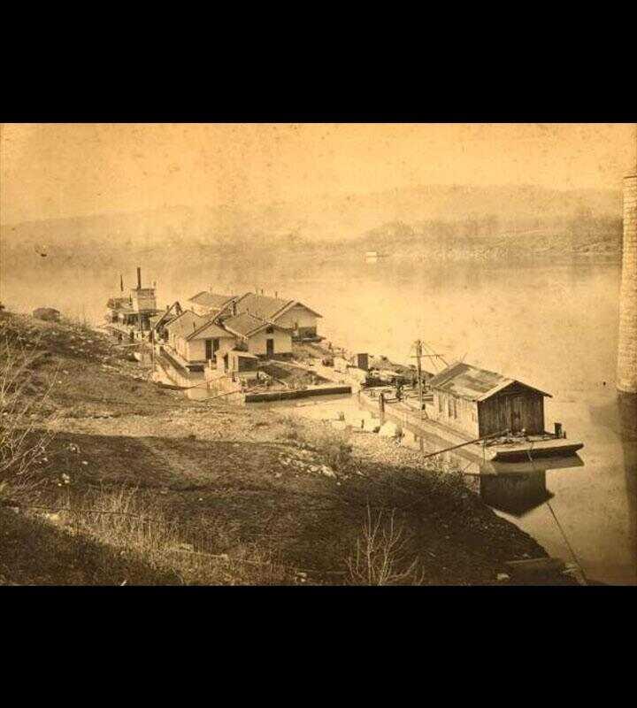 1889 photograph of the Tennessee River Fleet docks as Ross's Landing. A column of the Walnut Street Bridge is visible to the right.