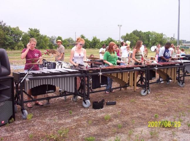 Students line up playing multiple marimbas 