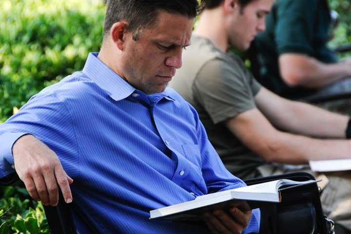 Translators Man reading book on bench