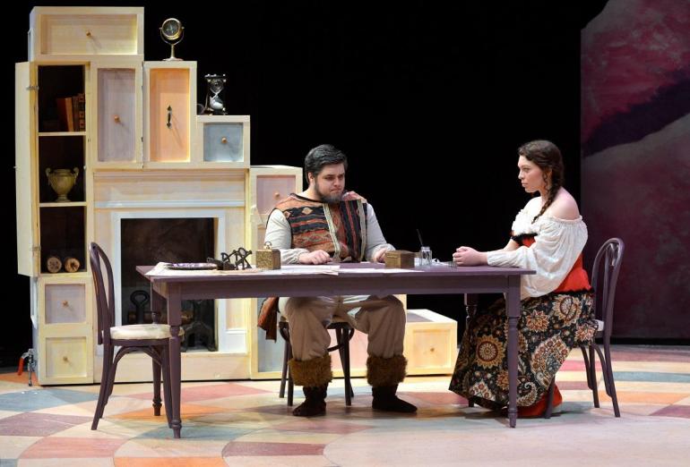 male and female cast member sit at dining table