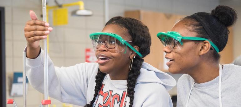 Two chemistry students looking at tube