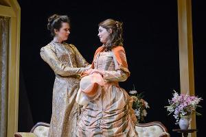two women in early 20th century dresses on stage