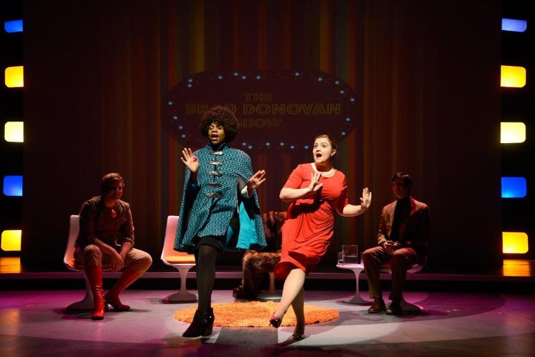 Two cast members dance on stage