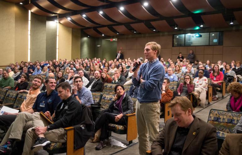 Man stands up and asks question in auditorium