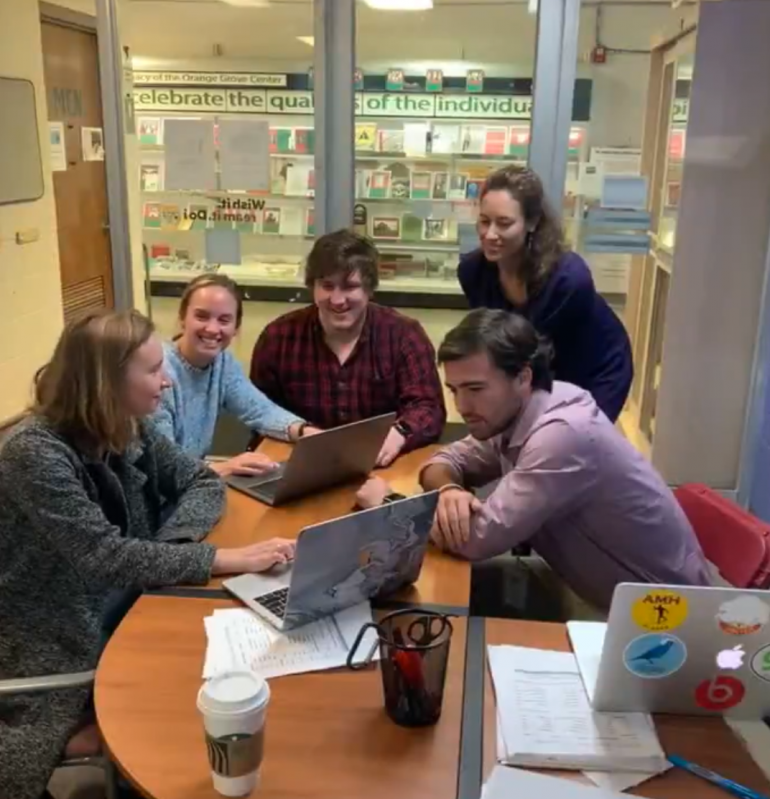 Career Community people at a table looking at a laptop