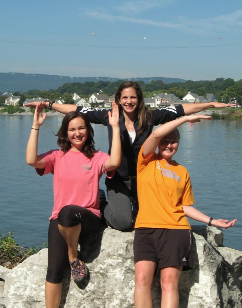 Students holding arms in UTC pose on riverwalk
