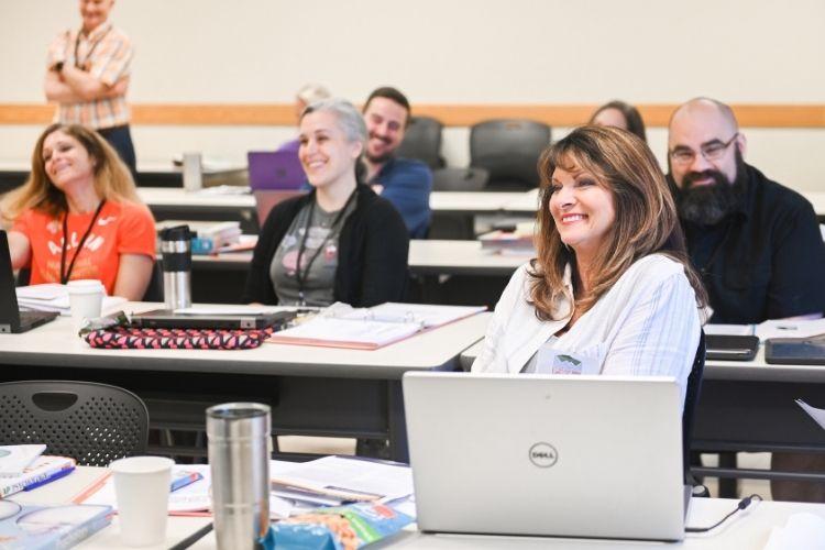 AP Teachers sitting in a classroom listening to Dr. O'Leary Present