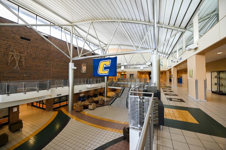wide shot of UTC University Center Atrium, with a Power C flag suspended from the trusses