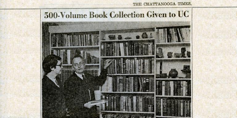 Chattanooga Times newspaper article entitled "500-Volume Book Collection Given to UC." Beneath the title there are two men in suits positioned in front of a full bookshelf engaging in conversation. The bookshelf displays monographs and ceramics such as vessels and figurines. 