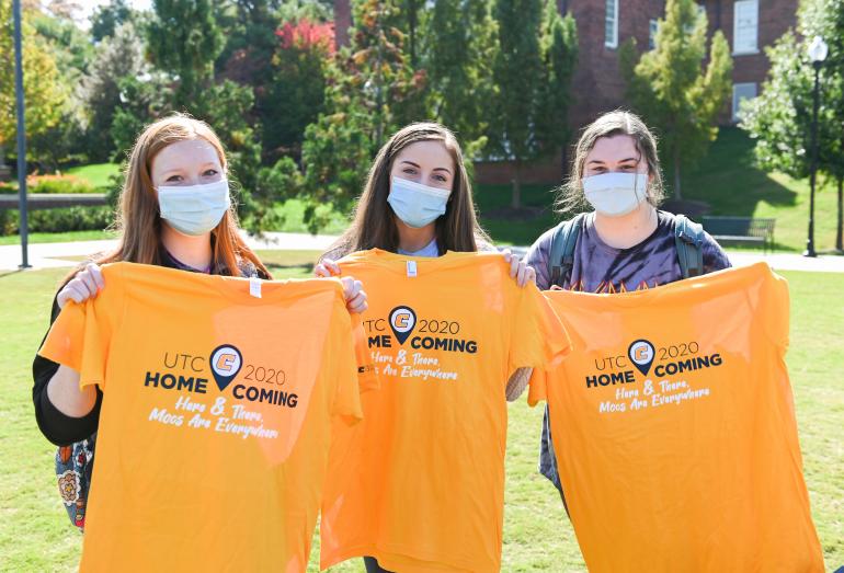 Homecoming 2020 Three students hold up homecoming t-shirts