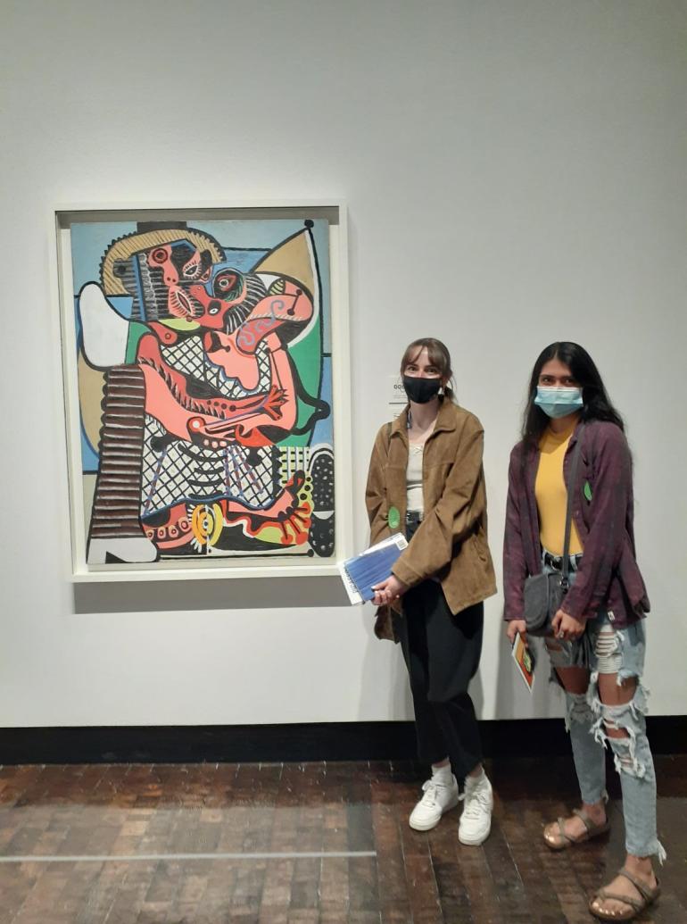 Students standing next to a painting