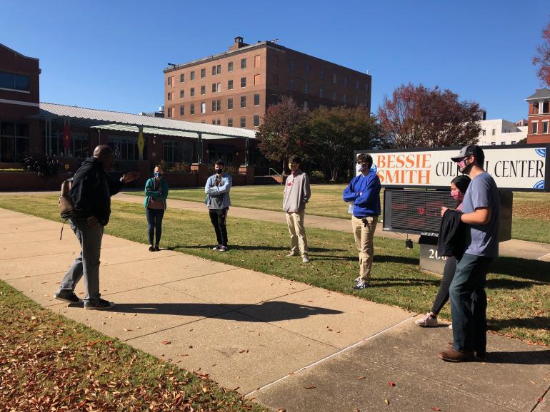 Students standing in a circle outside public buildings