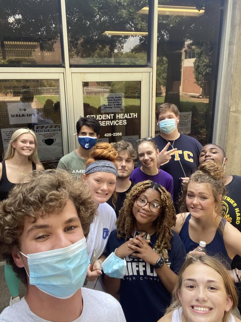 Students taking a selfie in front of glass windows