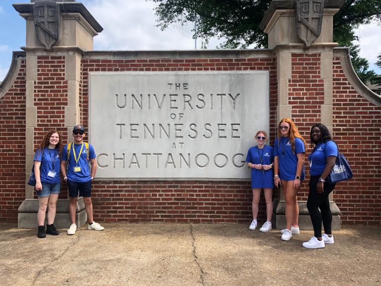 Students posing in front of UTC wall