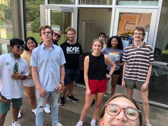 Students taking a selfie in front of glass windows