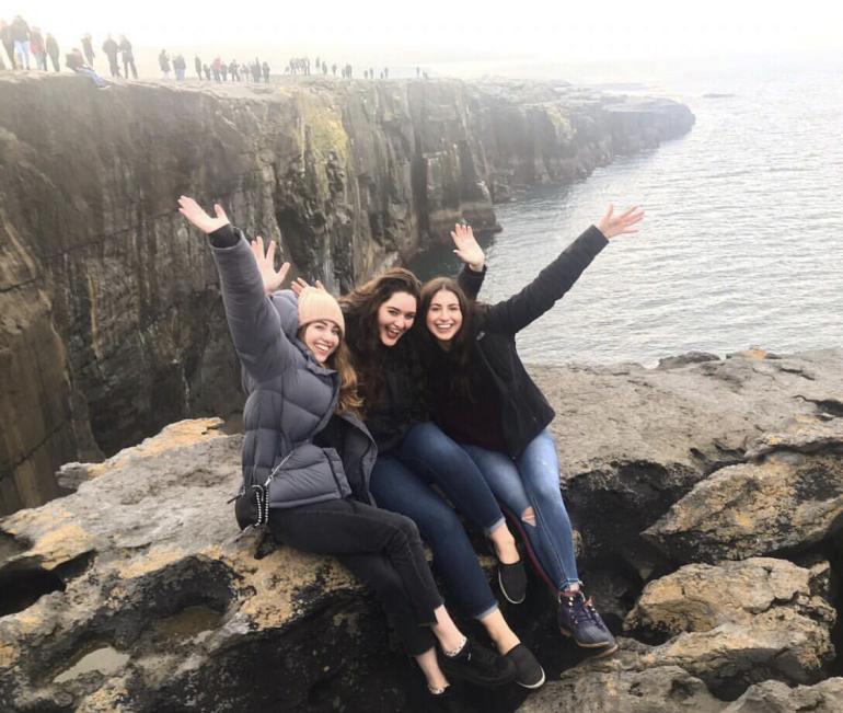 3 Students posing on a rocky cliffside