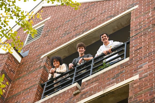 Male students looking down fromt the balcony.