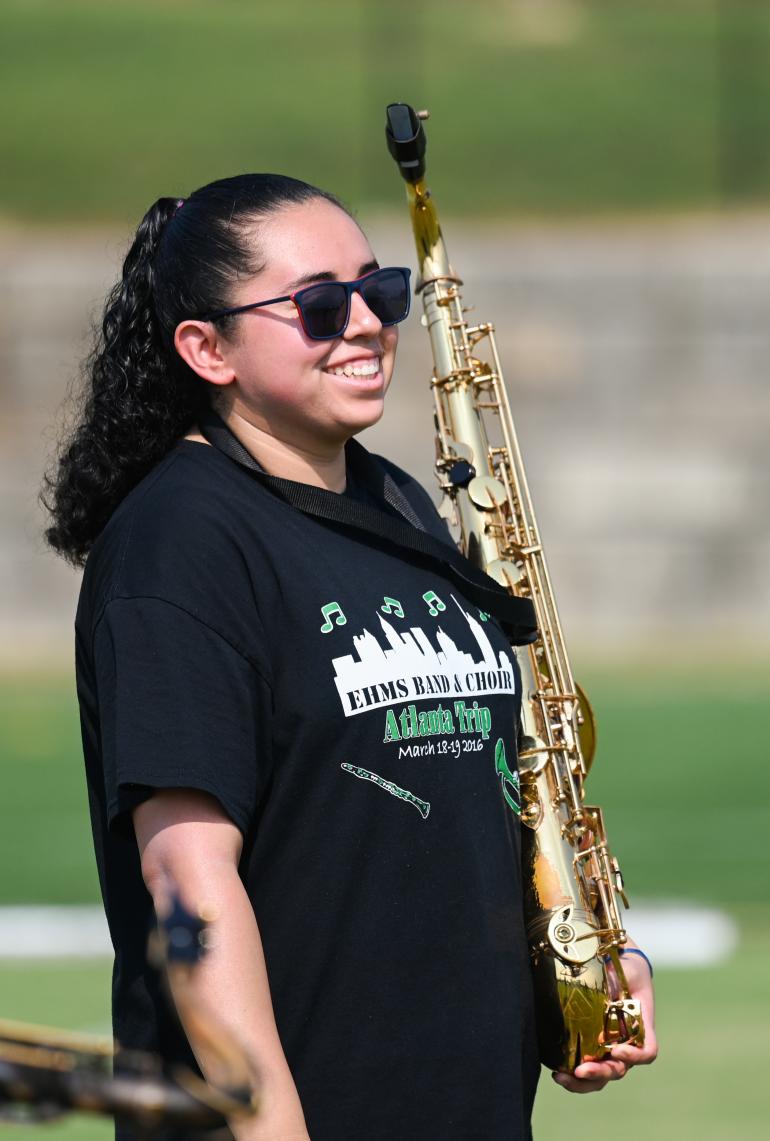 Woman holding baritone saxophone