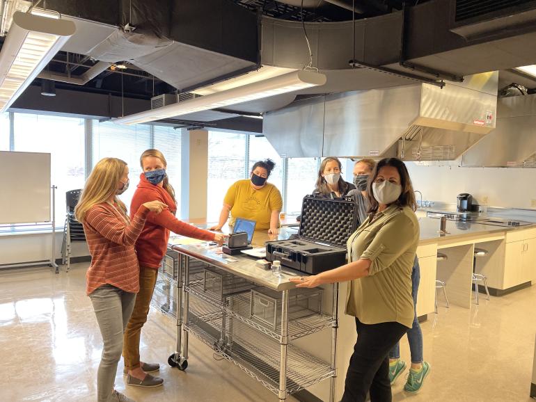 MPH students posing for picture around a kitchen island