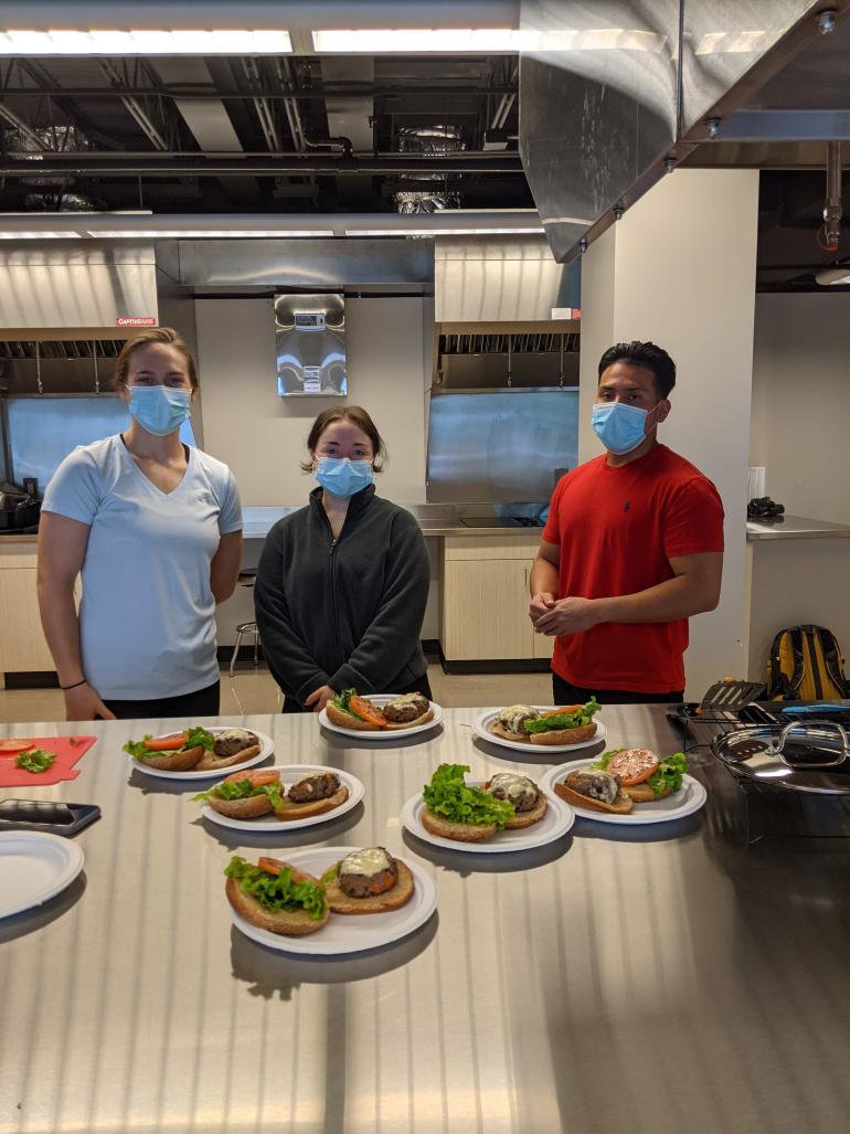 Three MPH ND students in front of burgers