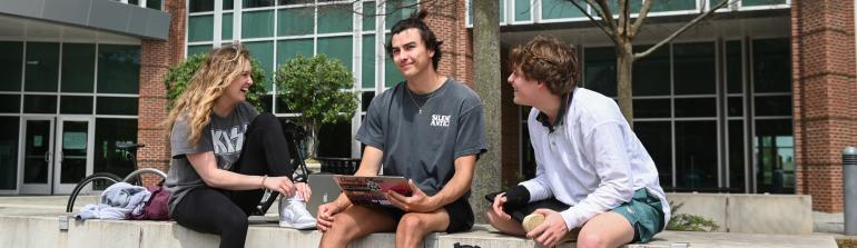 Three students outside the library Three students outside the library