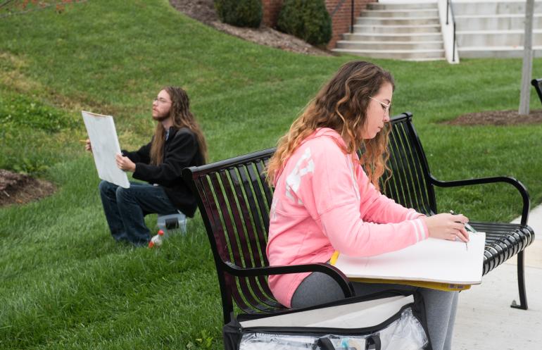 student drawing outside
