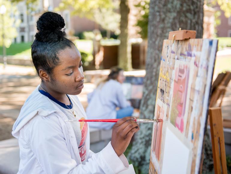 student painting outside