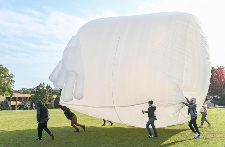 students outside with sculpture
