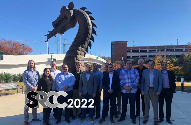 Group of faculty standing in front of dragon sculpture
