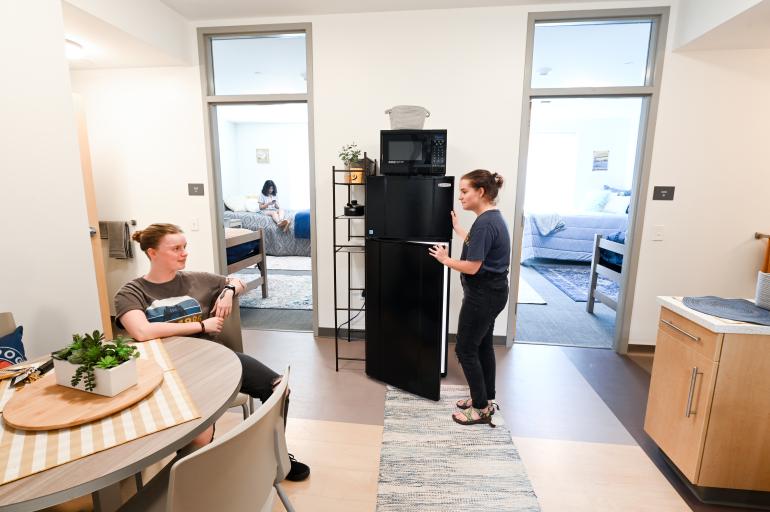 students in West Campus suite, at table and fridge