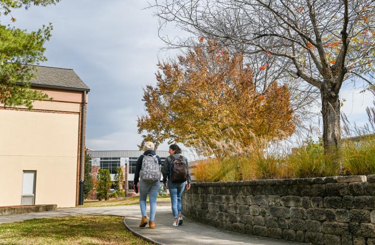 two students walking past Boling apartments toward the ARC