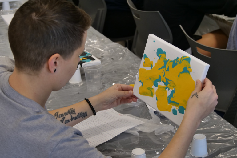 A student creating pour paint art